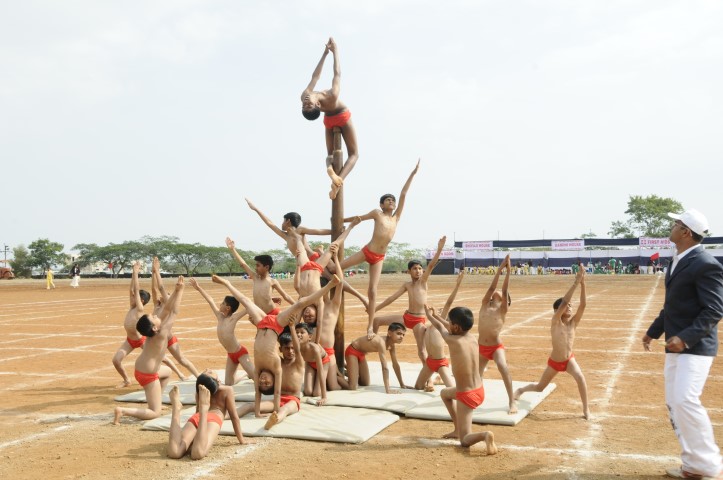 Students performing mallakhamb on the sports ground